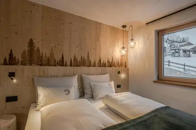 a bedroom with a large bed with a wooden ceiling at Bio Lüch Ruances in San Cassiano