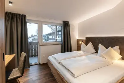 a hotel room with a bed and a window at Alpenrose Alpine Living in Selva