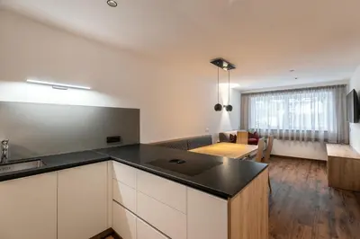 a kitchen and a living room with a table at Alpenrose Alpine Living in Selva