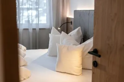 a bedroom with white pillows on a bed at Alpenrose Alpine Living in Selva