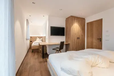 a hotel room with a bed and a desk at Alpenrose Alpine Living in Selva