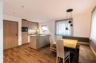 a kitchen and dining room with a table and chairs at Alpenrose Alpine Living in Selva