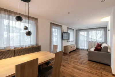 a living room with a table and a couch at Alpenrose Alpine Living in Selva