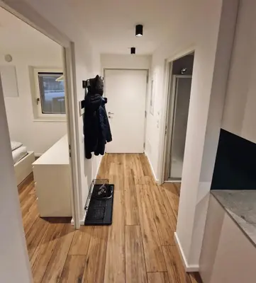a hallway of a house with a mirror and a door at M&M-Apartment in Brunico