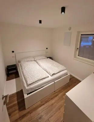 a bedroom with a white bed with a window at M&M-Apartment in Brunico