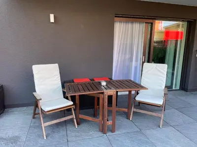 a wooden table and two chairs with red napkins on it at M&M-Apartment in Brunico