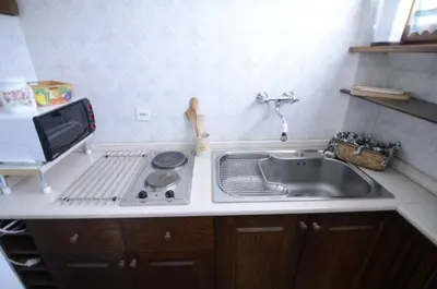 a small kitchen with a sink and a microwave at Cà Mughi Studio in Zuel