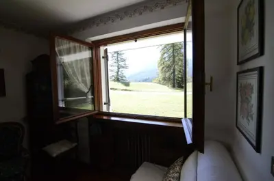 a window in a room with a view of a field at Cà Mughi Studio in Zuel