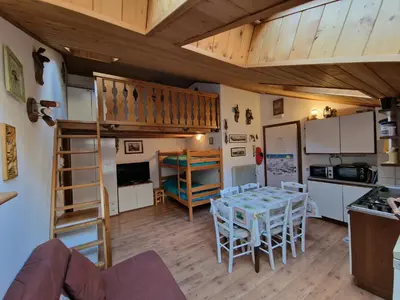 a room with a table and a bunk bed at Appartamento Latemar Predazzo in Predazzo