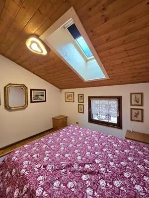 a bedroom with a large bed with a purple blanket at Appartamento Latemar Predazzo in Predazzo
