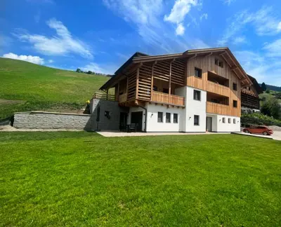 a house with a green lawn in front of it at Chalet Soredlin in La Valle