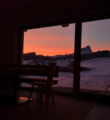 a room with a window with a bench and a sunset at Chalet Soredlin in La Valle