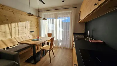 a small kitchen with a wooden table and a dining room at Chalet Soredlin in La Valle