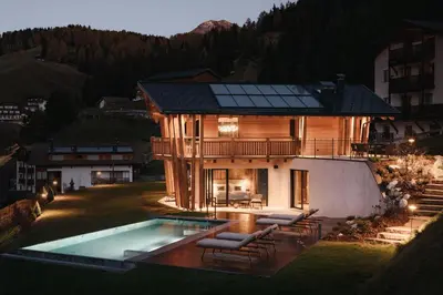 a house with a swimming pool in the yard at Luxury Spa Chalet Lum d'Or in Selva di Val Gardena