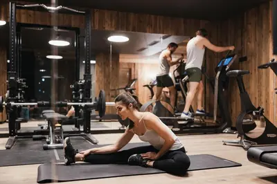 a woman sitting on a yoga mat in a gym at Luxury Spa Chalet Lum d'Or in Selva di Val Gardena