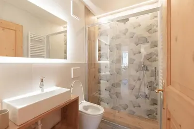 a bathroom with a toilet and a sink and a shower at Francesca's home in Pozza di Fassa