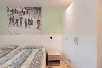 a bedroom with two beds and a painting on the wall at Francesca's home in Pozza di Fassa