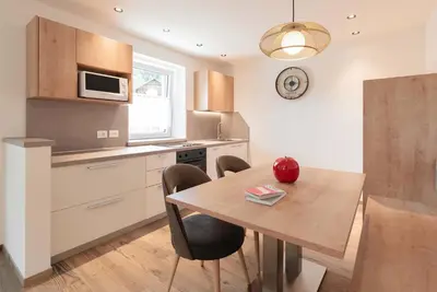 a kitchen with a table and chairs and a microwave at Francesca's home in Pozza di Fassa