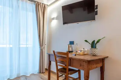 a wooden table with a chair and a television on a wall at B&B El Lares - B&B L'Avez in Canale dʼAgordo