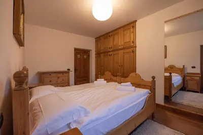 a living room with two couches and a chandelier at Casa Da l Oio in Cortina dʼAmpezzo