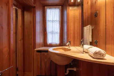 a kitchen with a wooden table and chairs at Casa Da l Oio in Cortina dʼAmpezzo