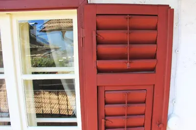 a red door in front of a window at Cirillo Guesthouse in Cortaccia