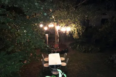 a table and chairs in a garden at night at Cirillo Guesthouse in Cortaccia