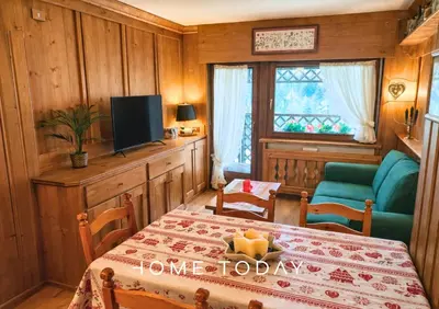 a dining room with a table and a television at Hometoday - Appartamento nel cuore di San Vito di Cadore in San Vito di Cadore