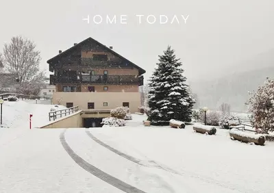 a snow covered road in front of a building at Hometoday - Appartamento nel cuore di San Vito di Cadore in San Vito di Cadore