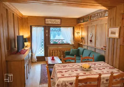 a dining room with a table and a television at Hometoday - Appartamento nel cuore di San Vito di Cadore in San Vito di Cadore