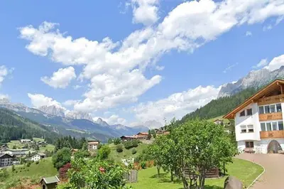 a view of a village with mountains in the background at Ciasa Gran Panorama Moena in Moena