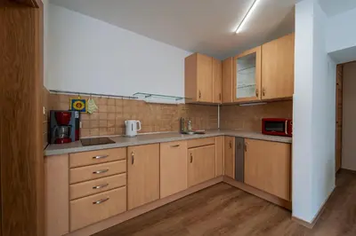 a kitchen with wooden cabinets and a microwave at Mias Apartments in Rablà