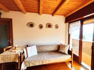 a living room with a couch and a table at Falcade Dolomiti La Quiete Mansarda panoramica in Fregona