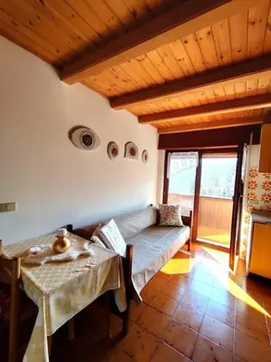 a living room with a couch and a table at Falcade Dolomiti La Quiete Mansarda panoramica in Fregona
