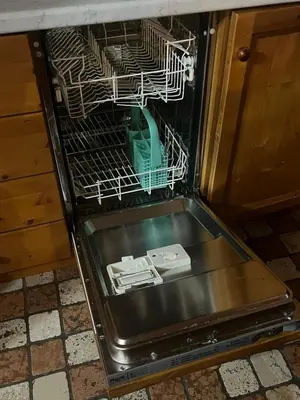 an open dishwasher with a dish rack in it at Casa De Lotto in San Vito di Cadore