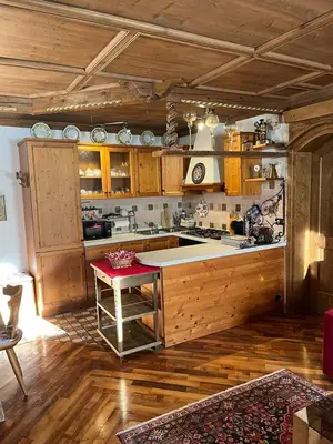 a kitchen with wooden cabinets and a table in a room at Casa De Lotto in San Vito di Cadore