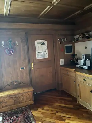 a room with a wooden door and a table and a counter at Casa De Lotto in San Vito di Cadore