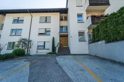 a white building with a red door and a driveway at Mias Apartments - #MiasEppan#Badl in Appiano sulla Strada del Vino