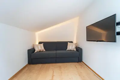 a living room with a couch and a flat screen tv at Mias Apartments - #MiasEppan#Badl in Appiano sulla Strada del Vino
