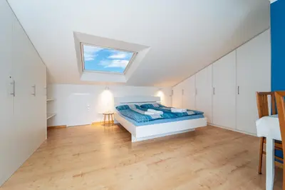 a attic bedroom with a bed and a skylight at Mias Apartments - #MiasEppan#Badl in Appiano sulla Strada del Vino