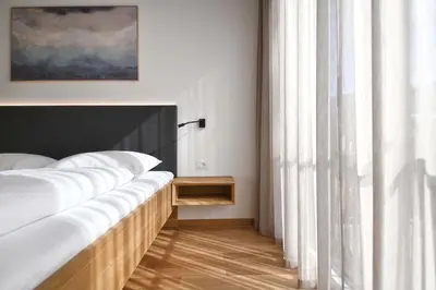 a bedroom with a bed with white sheets and a window at Apartments Johanna in Nalles