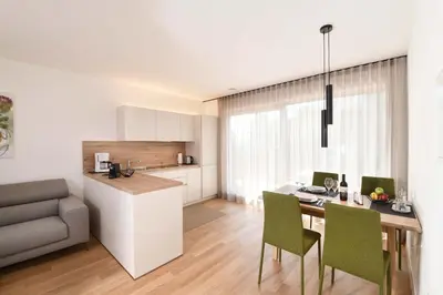a kitchen and living room with a table and chairs at Apartments Johanna in Nalles