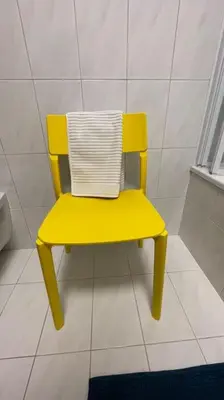 a yellow chair sitting on a tiled floor at Living Apartment Larcher in Verano