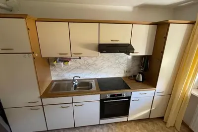 a small kitchen with white cabinets and a sink at Living Apartment Larcher in Verano