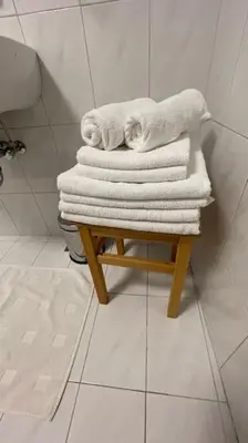 a pile of towels sitting on a stool in a bathroom at Living Apartment Larcher in Verano