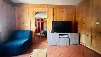 a living room with a blue couch and a flat screen tv at PredazzoHouse in Predazzo
