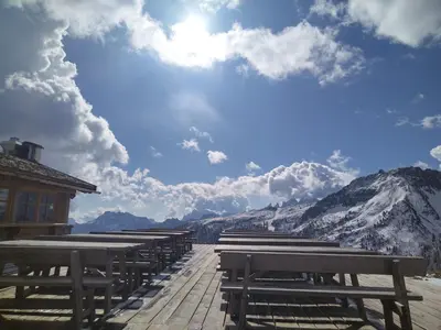 a row of benches on a boardwalk with a mountain at Casa FALCADE DOLOMITI in Canale dʼAgordo
