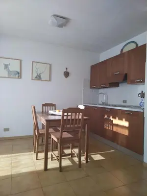 a kitchen with a wooden table and chairs in it at Casa FALCADE DOLOMITI in Canale dʼAgordo
