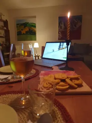 a table with a laptop computer and a glass of wine at Casa FALCADE DOLOMITI in Canale dʼAgordo