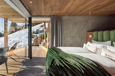 a bedroom with a large bed and a balcony at Luxury Chalet Vilaiet in Ortisei
